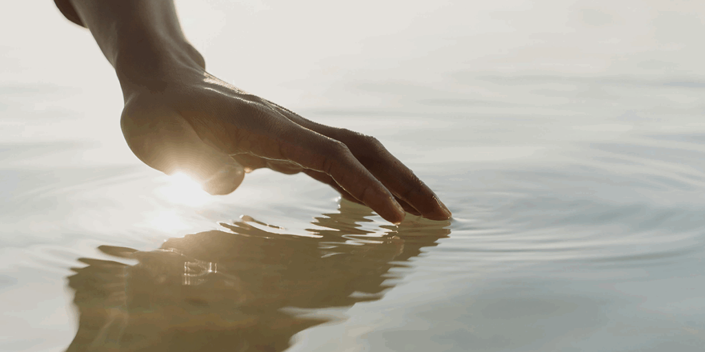 the hand touching the water surface. depicting the ease. Doing something is always more fun than just watching for a better future and life.