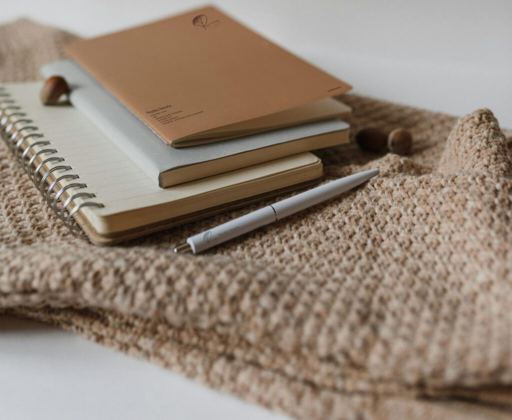 a pile of journal and a pen on the sack of brown color