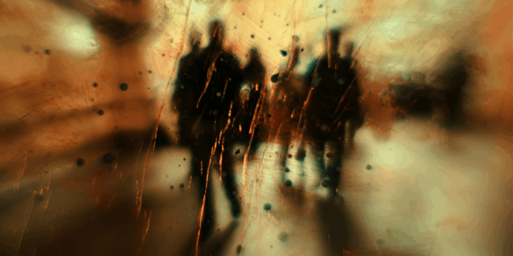 Photo of blurred window glass with rain drop on it but the group of people can be seen behind this glass window. Reflecting the idea of moving on