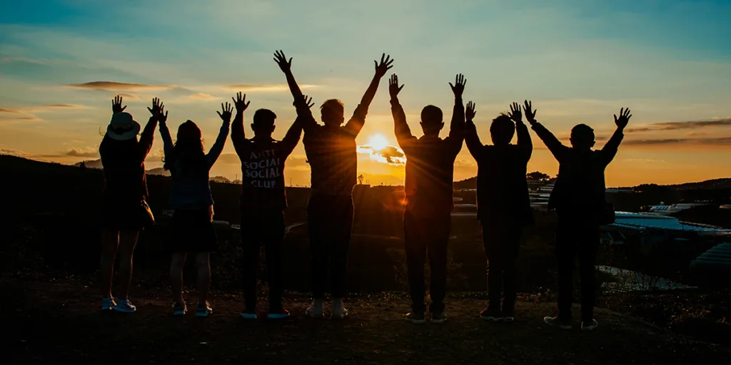Group of students standing on mountain peak reflecting inner strength and self-belief.