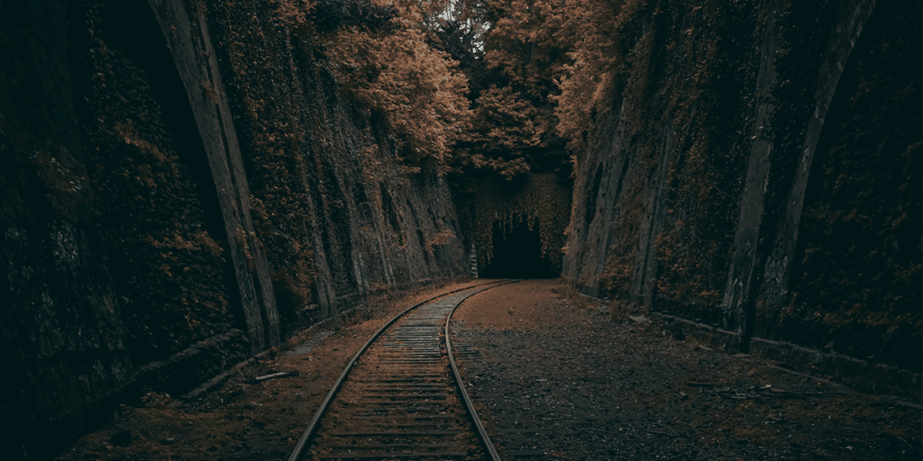 A pathway towards the tunnel in between two big mountains covered with the autumn yellow leaves and tress. There Is No Tunnel Without an Exit: Trusting Life’s Darkest Moments